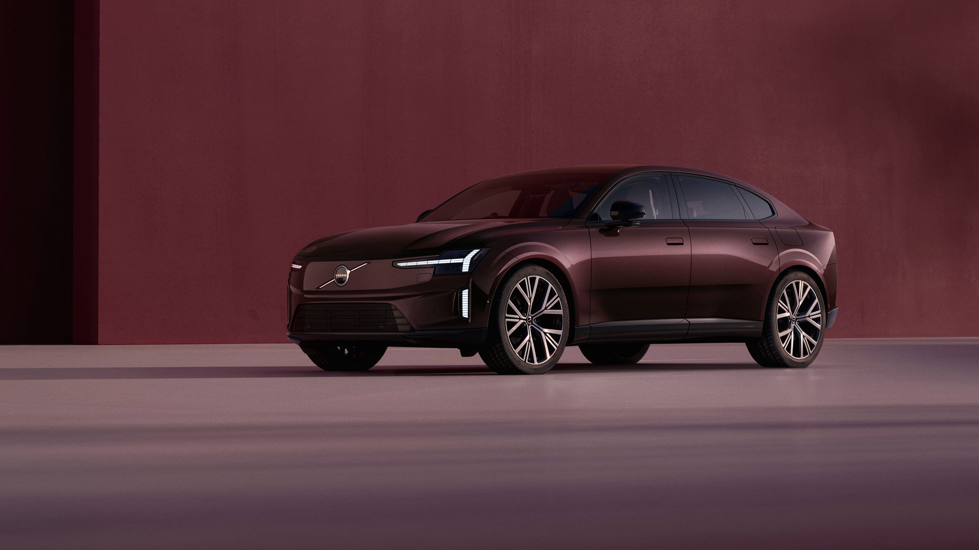 En Mulberry red Volvo Es90 stende i et studio i samme farger